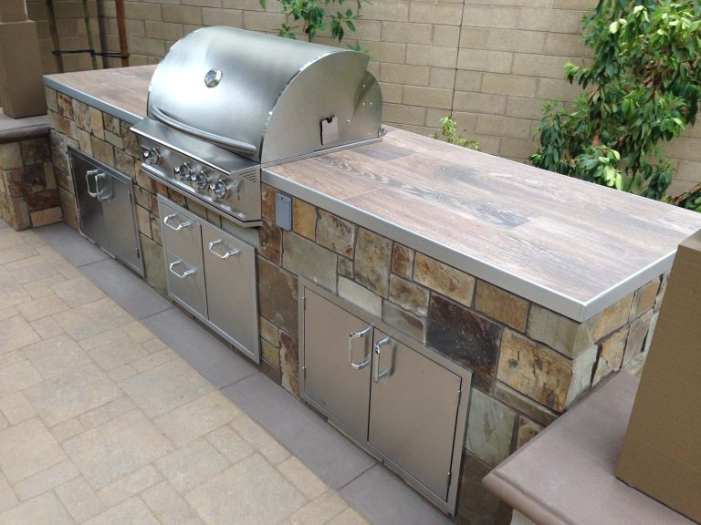 Patio kitchen - mid-sized contemporary backyard stone patio kitchen idea in Orange County with a roof extension