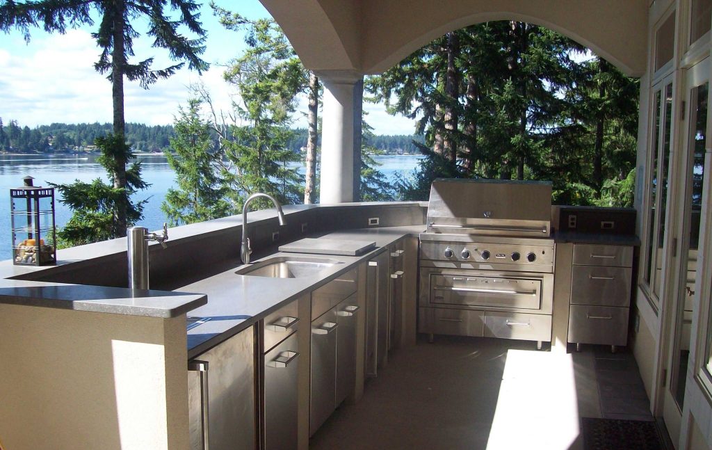 Patio kitchen - mid-sized craftsman backyard concrete paver patio kitchen idea in Seattle with a roof extension