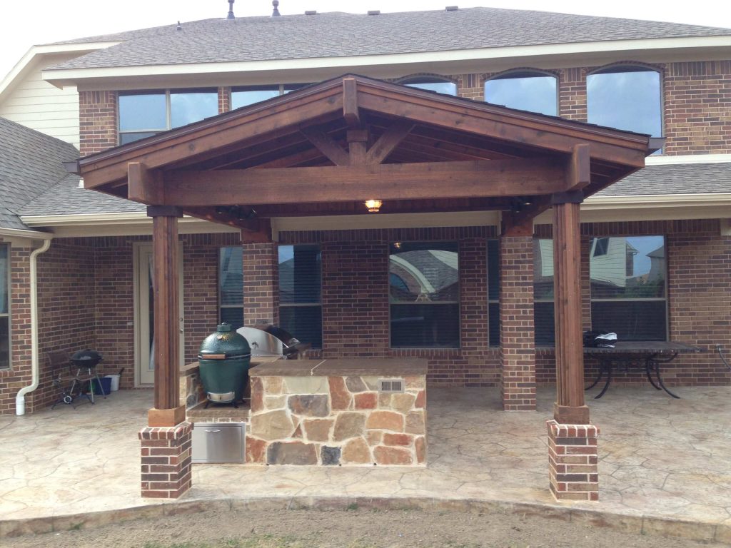 Patio kitchen - mid-sized rustic backyard stamped concrete patio kitchen idea in Dallas with an awning