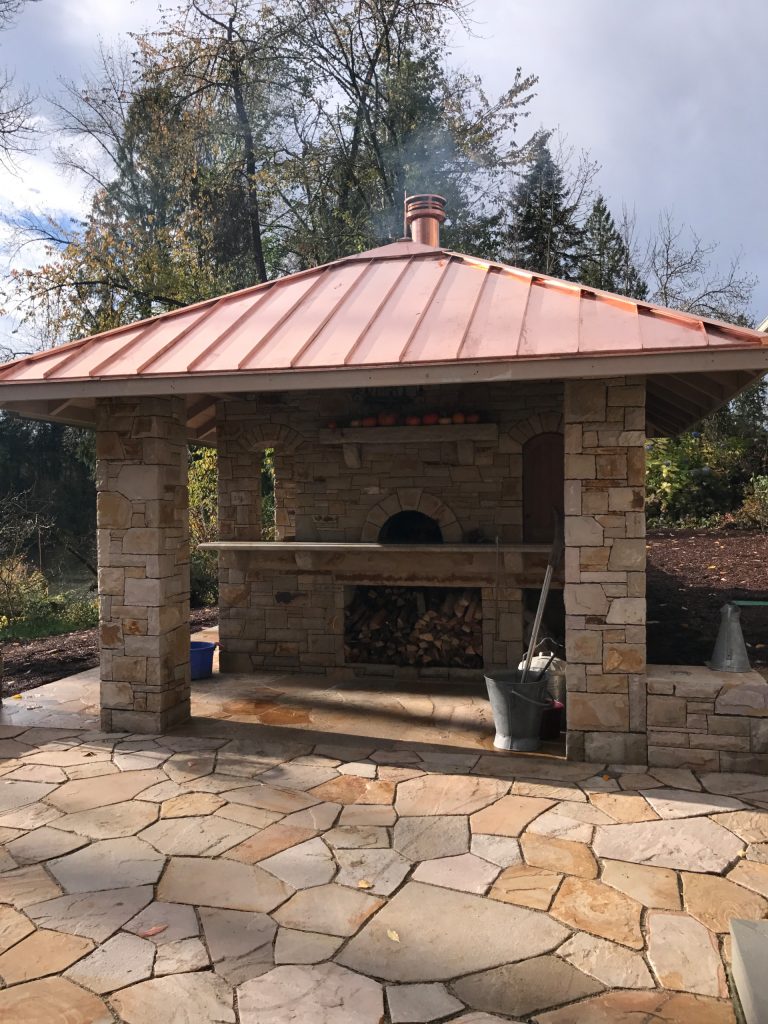 Patio kitchen - mid-sized rustic backyard stone patio kitchen idea in Portland with a gazebo
