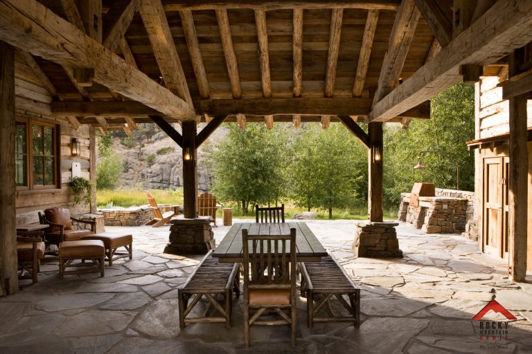 Patio kitchen - mid-sized rustic side yard stone patio kitchen idea in Other with a roof extension
