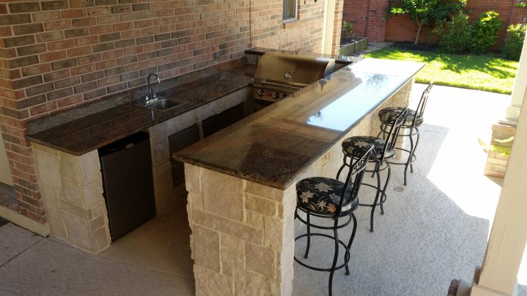 Patio kitchen - mid-sized traditional backyard concrete patio kitchen idea in Houston with a roof extension