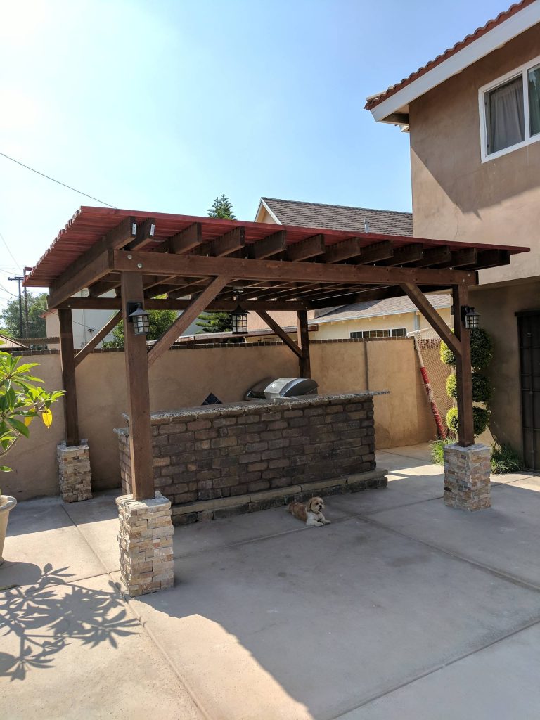 Patio kitchen - mid-sized traditional backyard concrete patio kitchen idea in Los Angeles with a pergola