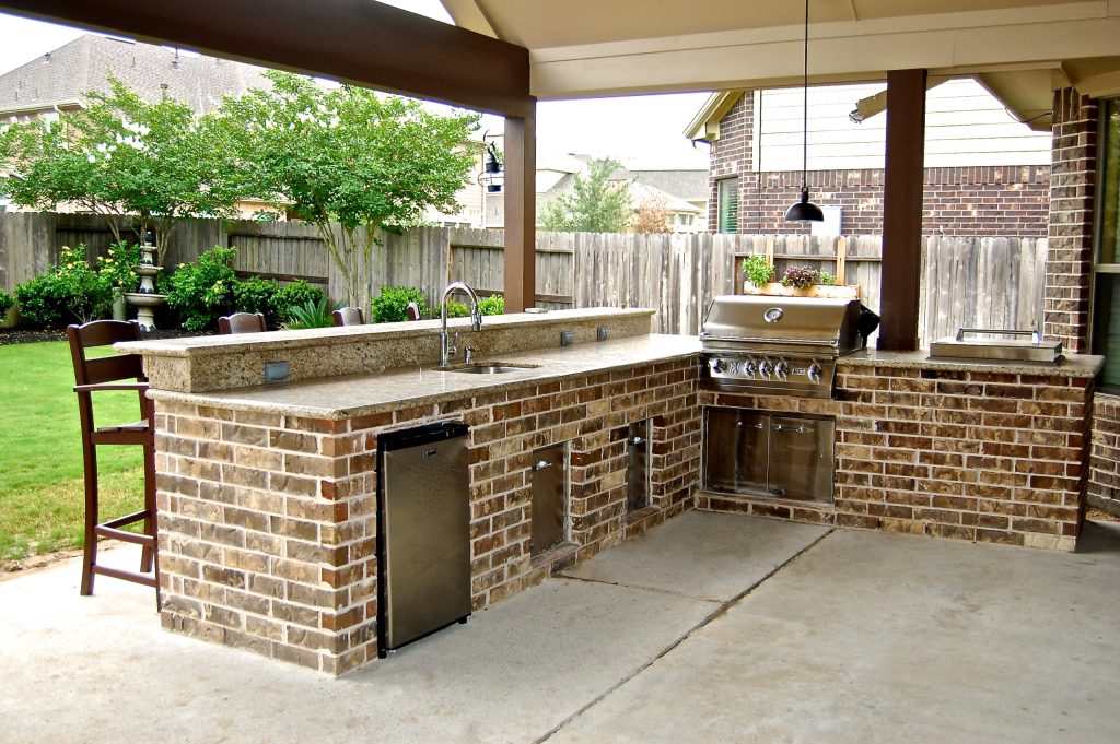 Patio kitchen - mid-sized traditional backyard patio kitchen idea in Houston with a roof extension