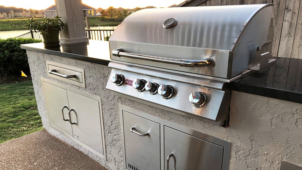 Patio kitchen - mid-sized traditional backyard stamped concrete patio kitchen idea in Houston with a pergola