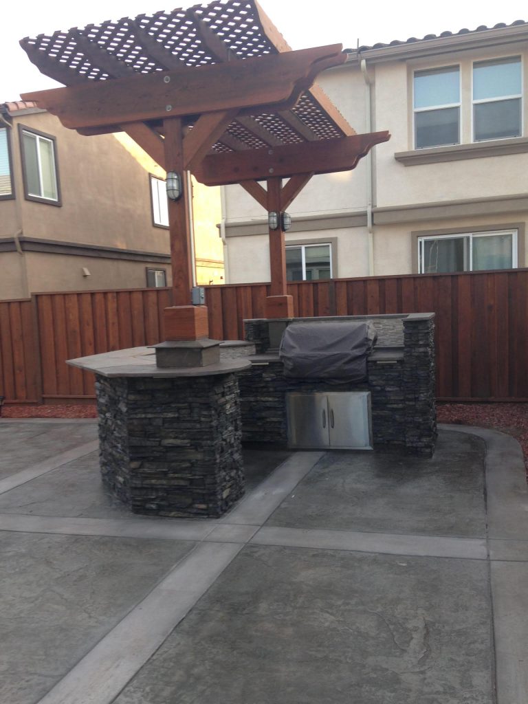 Patio kitchen - mid-sized traditional backyard stamped concrete patio kitchen idea in San Francisco with a pergola