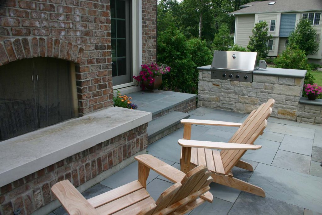 Patio kitchen - mid-sized traditional backyard stone patio kitchen idea in Chicago with no cover
