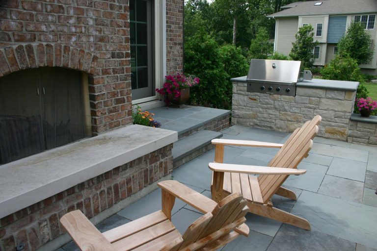 Patio kitchen - mid-sized traditional backyard stone patio kitchen idea in Chicago with no cover