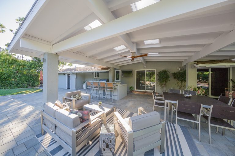 Patio kitchen - mid-sized traditional backyard stone patio kitchen idea in Orange County with a roof extension