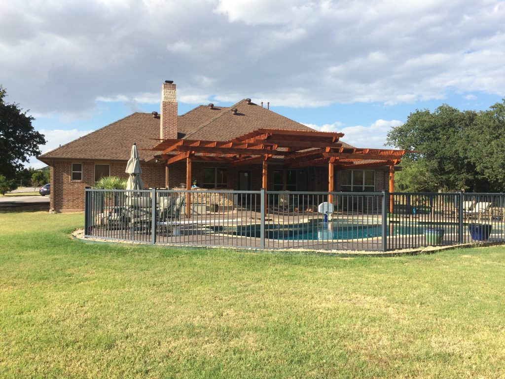 Patio kitchen - mid-sized transitional backyard brick patio kitchen idea in Austin with a pergola