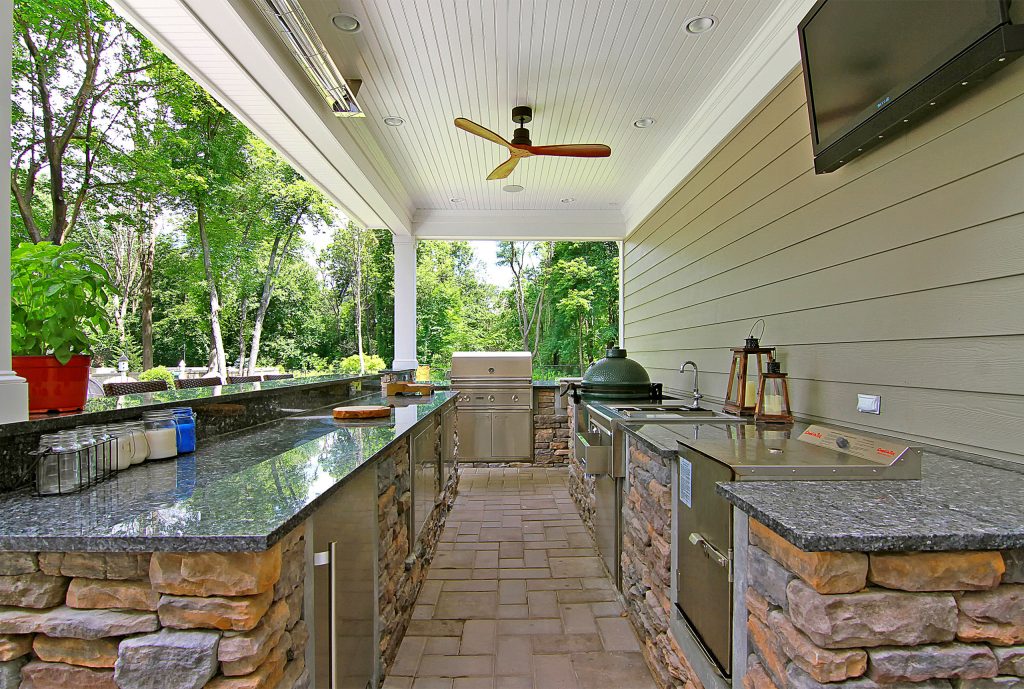 Patio kitchen - mid-sized transitional backyard brick patio kitchen idea in New York with a roof extension