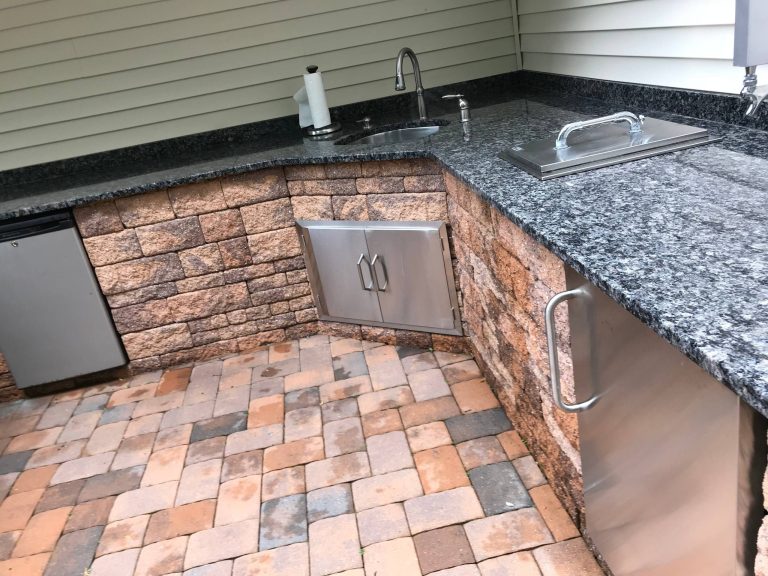 Patio kitchen - mid-sized transitional backyard brick patio kitchen idea in New York with an awning