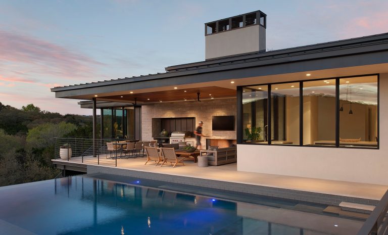 Patio kitchen - modern backyard stone patio kitchen idea in Austin with a roof extension