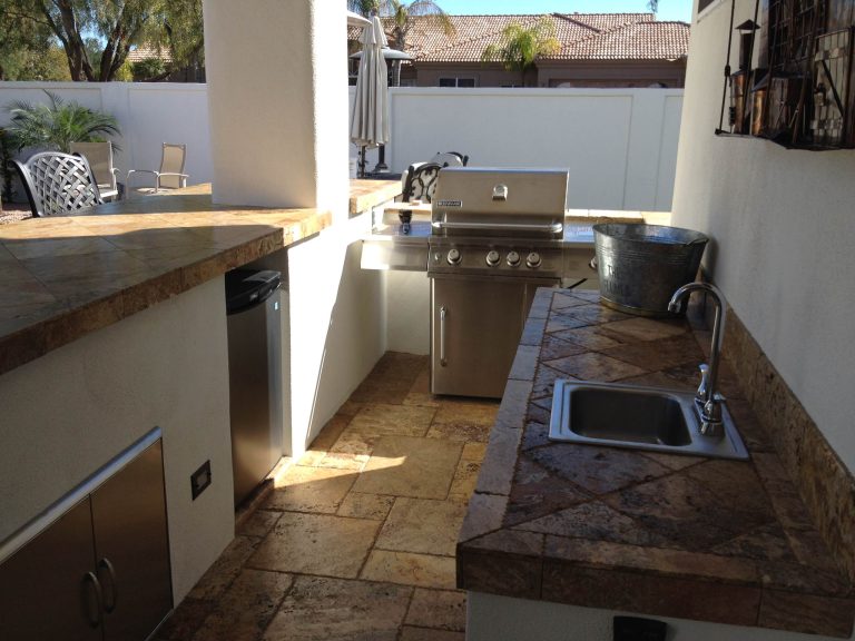 Patio kitchen - small backyard stamped concrete patio kitchen idea in Phoenix with a roof extension