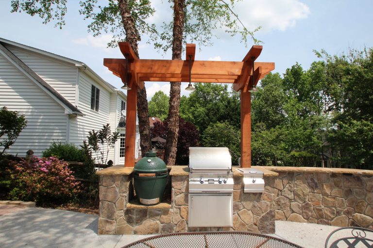 Patio kitchen - small contemporary backyard stone patio kitchen idea in Charlotte with a pergola