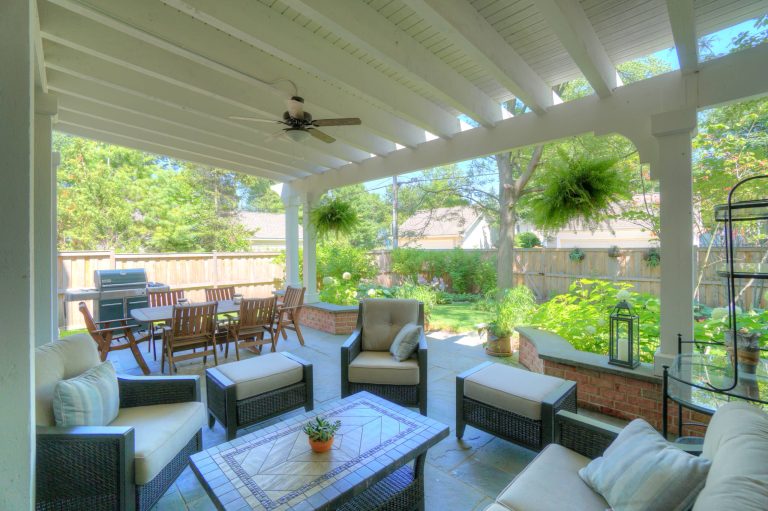 Patio kitchen - small traditional backyard stone patio kitchen idea in Chicago with a pergola