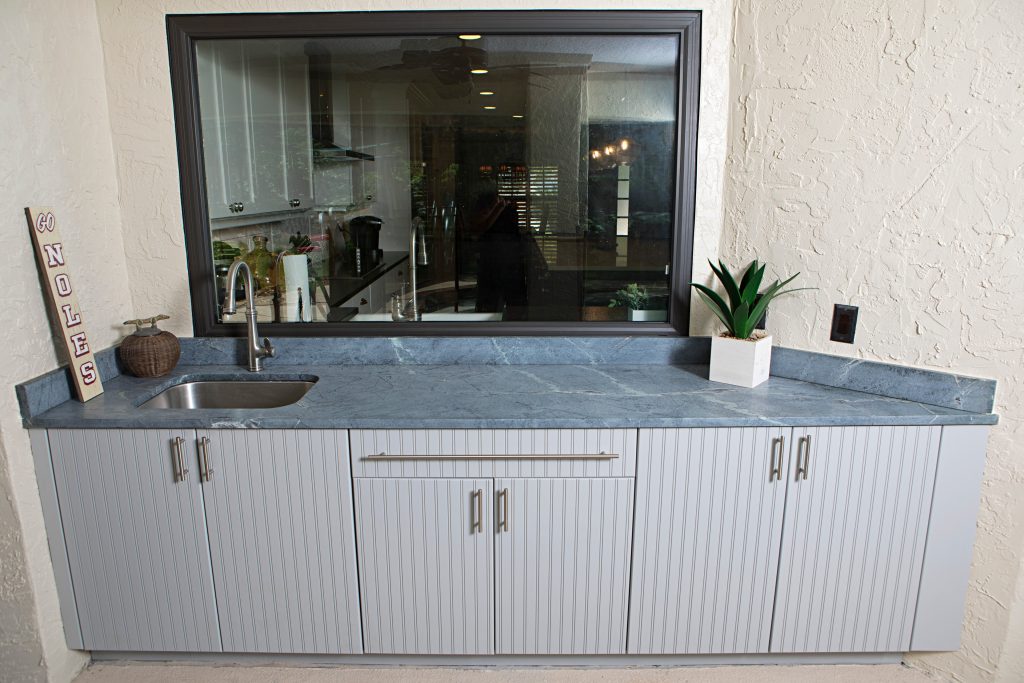 Patio kitchen - small transitional backyard patio kitchen idea in Orlando