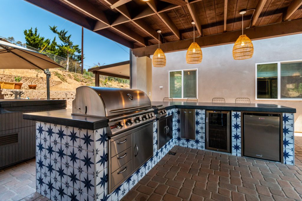 Patio kitchen - traditional patio kitchen idea in San Diego with a pergola