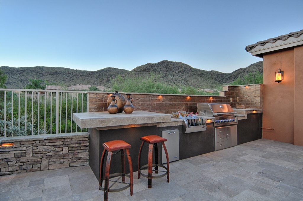 Patio kitchen - transitional backyard stone patio kitchen idea in Phoenix