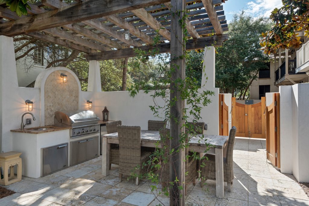 Patio kitchen - transitional courtyard stone patio kitchen idea in Other with a pergola