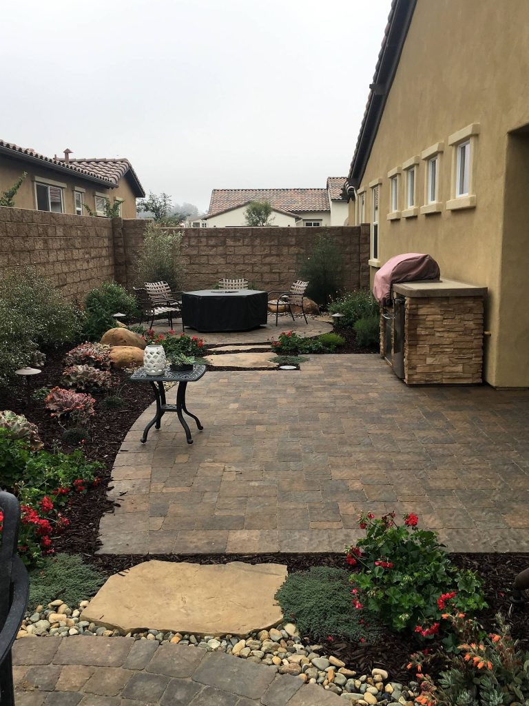 Patio made of pavers with custom outdoor kitchen.