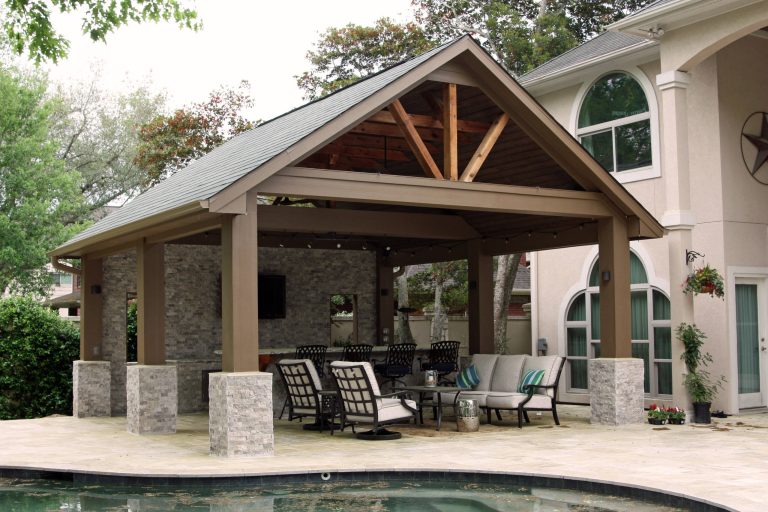 Patio with outdoor kitchen custom designed and built by Dynamic Pools & Patios. Photo by Angela Morrill © 2018