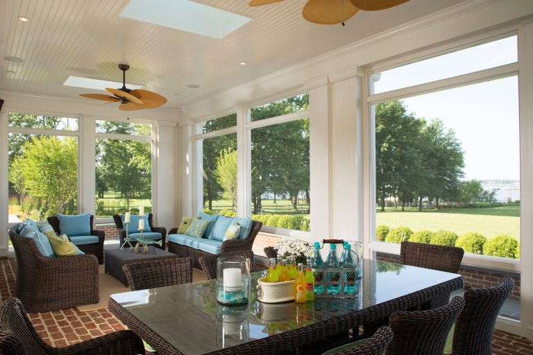 Perfect for entertaining, this sunroom features ample seating, dining area, skylights, ceiling fans, and expansive water views. David Burroughs