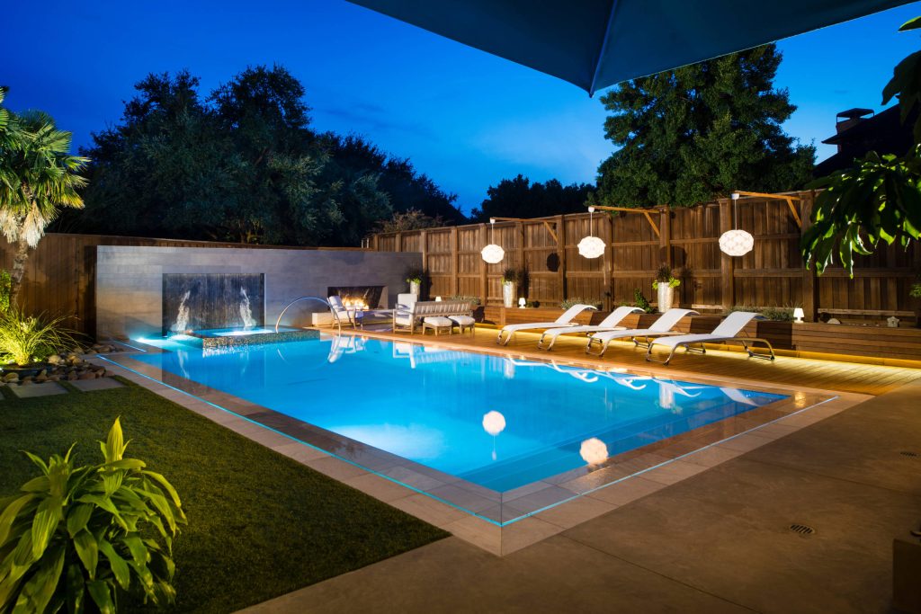 Perimeter overflow pool with raised spa and fireplace