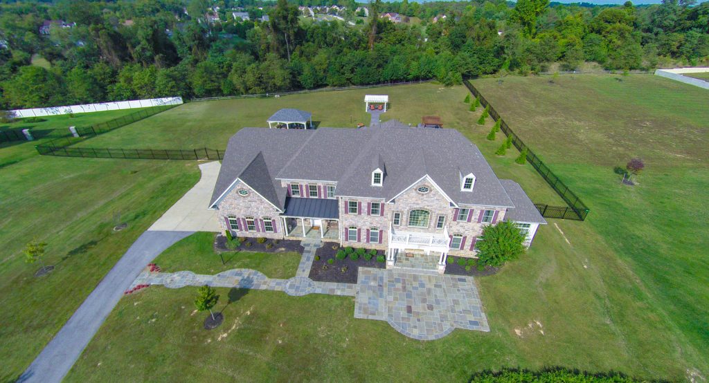Photo by Matchbook Productions - aerial view using Go Pro camera; front yard patio and walkway using blue variegated flagstone; curves enhance curb appeal while accenting architecture of home