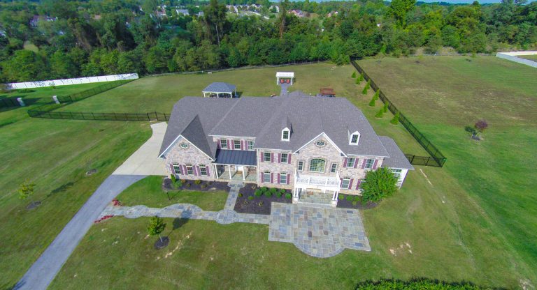 Photo by Matchbook Productions - aerial view using Go Pro camera; front yard patio and walkway using blue variegated flagstone; curves enhance curb appeal while accenting architecture of home