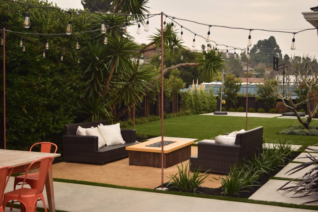 Photo of a contemporary backyard concrete paver outdoor sport court in San Francisco with a fire pit.