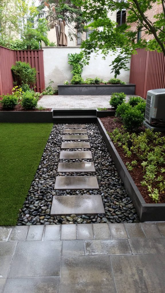 Photo of a small contemporary backyard stone landscaping in New York.