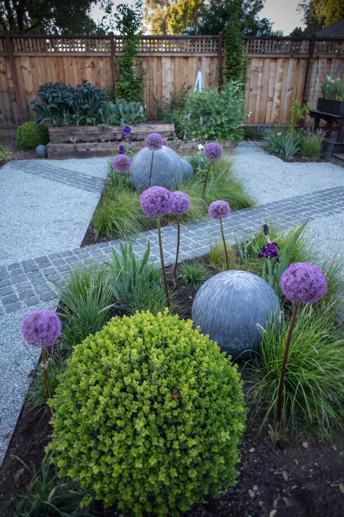 Photo of a small contemporary partial sun backyard stone flower bed in Other.