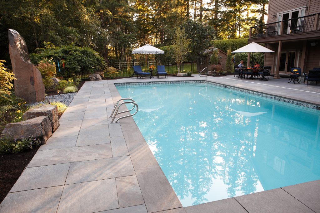 Pool fountain - large contemporary backyard stone and rectangular lap pool fountain idea in Seattle