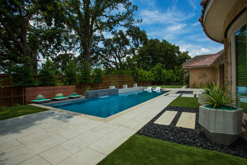 Pool fountain - mid-sized modern backyard rectangular pool fountain idea in Dallas with decking