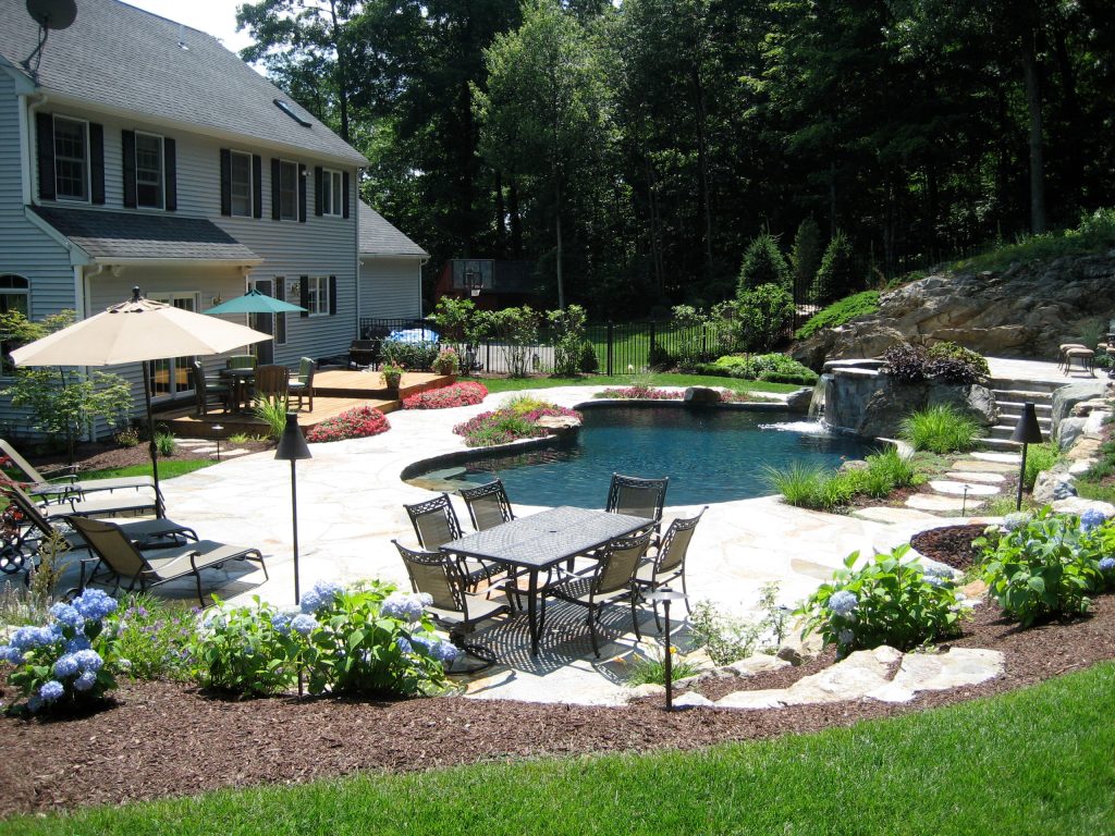 Pool fountain - mid-sized traditional backyard stone and custom-shaped natural pool fountain idea in New York
