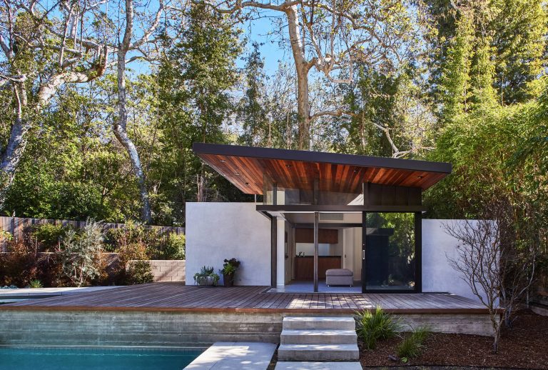 Pool house - contemporary backyard rectangular pool house idea in Los Angeles with decking