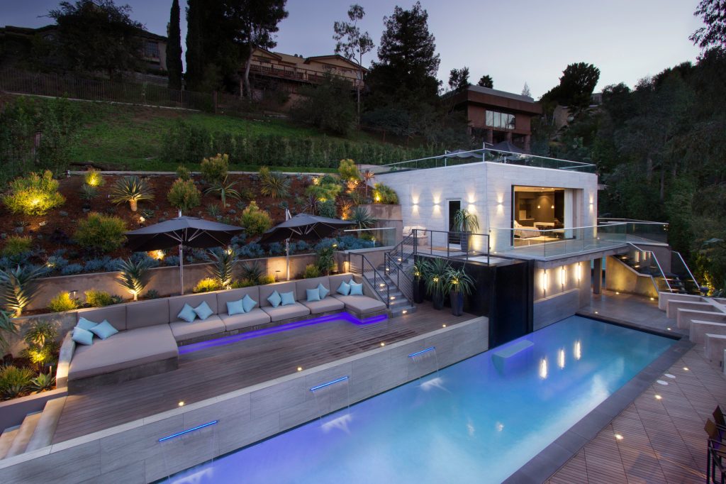 Pool house - large contemporary backyard rectangular lap pool house idea in Los Angeles with decking