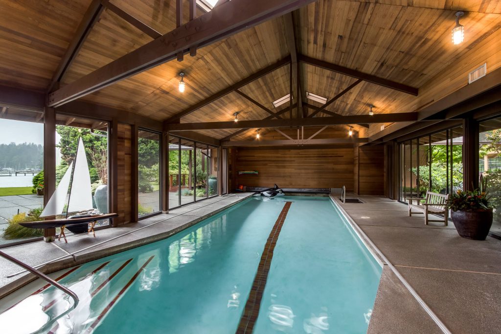 Pool house - large rustic indoor stamped concrete and rectangular lap pool house idea in Seattle