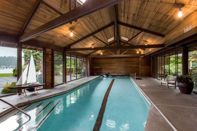 Pool house - large rustic indoor stamped concrete and rectangular lap pool house idea in Seattle