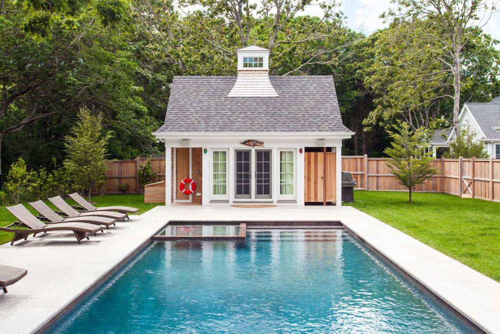Pool house - large traditional backyard concrete paver and rectangular pool house idea in Boston