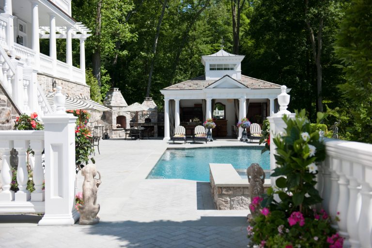 Pool house - large traditional backyard custom-shaped pool house idea in New York