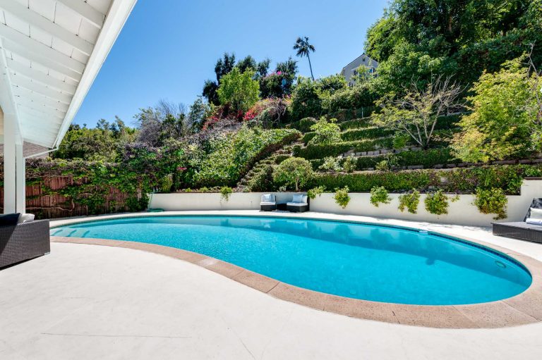 Pool - large mid-century modern backyard kidney-shaped and concrete paver natural pool idea in Los Angeles