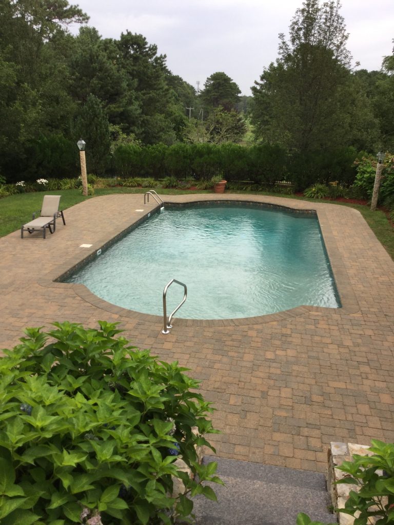 Pool - large traditional backyard brick lap pool idea in Boston