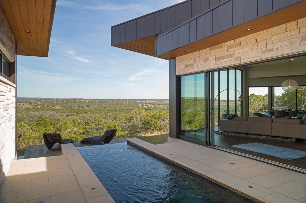Pool - mid-sized contemporary courtyard concrete paver and custom-shaped infinity pool idea in Austin