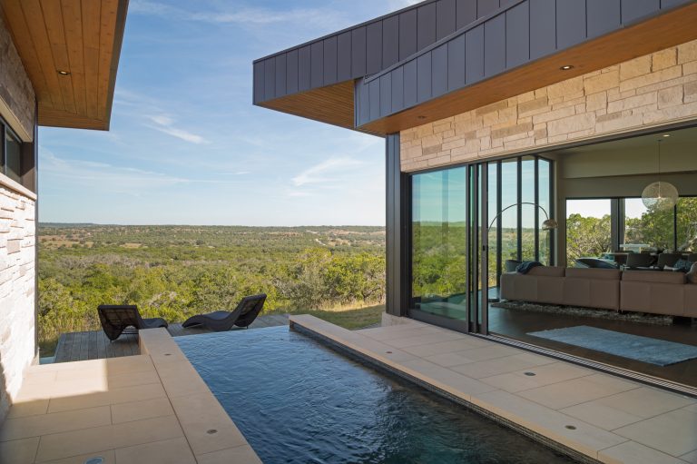 Pool - mid-sized contemporary courtyard concrete paver and custom-shaped infinity pool idea in Austin