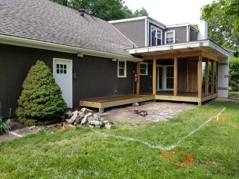 Porch soffit and wing wall ready for stucco, paver patio laid out with arbor footings
