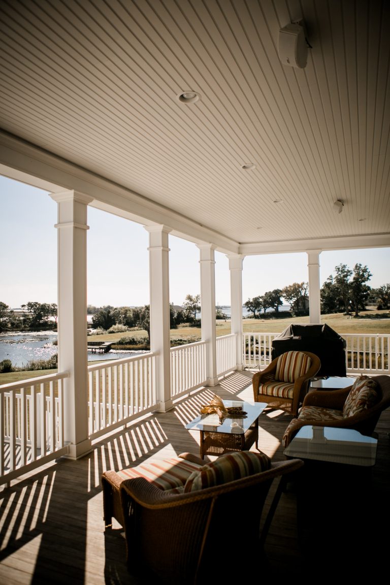 Porch with custom surround sound speaker system by Bose overlooks the picturesque waterfront, pool, and grand expanse of beautiful property.