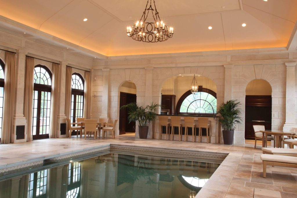 Private indoor pool space witih custom cabinetry, mouldings, windows, and doors.
