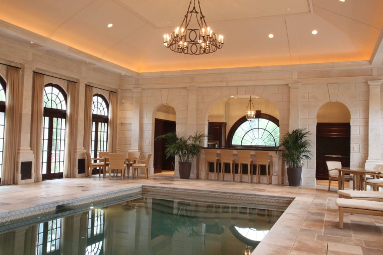 Private indoor pool space witih custom cabinetry, mouldings, windows, and doors.